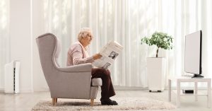 Eine Pensionärin, Oma, Großmutter in einem Ohrensessel, Die Zeitung lesend